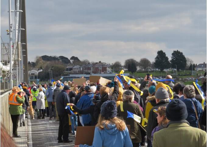Ribbons in the Ukrainian national colours of blue and yellow wave in the chilly breeze on the Tamar Bridge as the Cornish and Devon contingents of the walk of solidarity converge. Picture: Sue Hooper