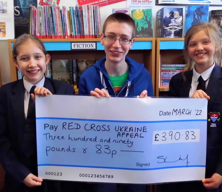 Teign School students Freya E (Year 8), Joseph B (6th Form) and Evelyn B (Year 7) proudly display our ‘Big Cheque’ for the Red Cross Ukraine Emergency Appeal.
Picture: Teign School (March 2022)