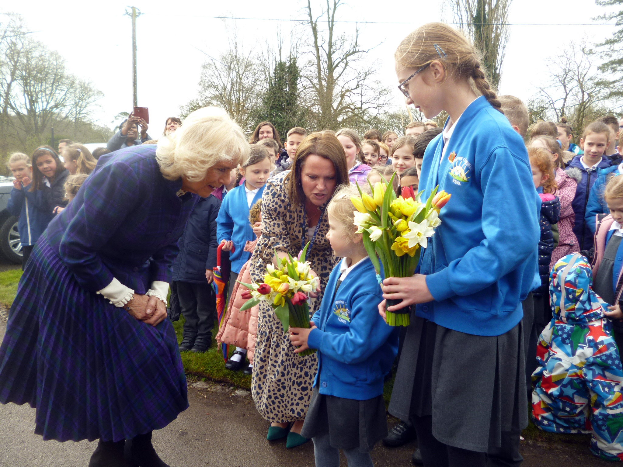 <p>The Duchess of Cornwall receives flowers from Chawton CE Primary School pupils Cecily Hook, four, and Holly Bayliss, 11</p>