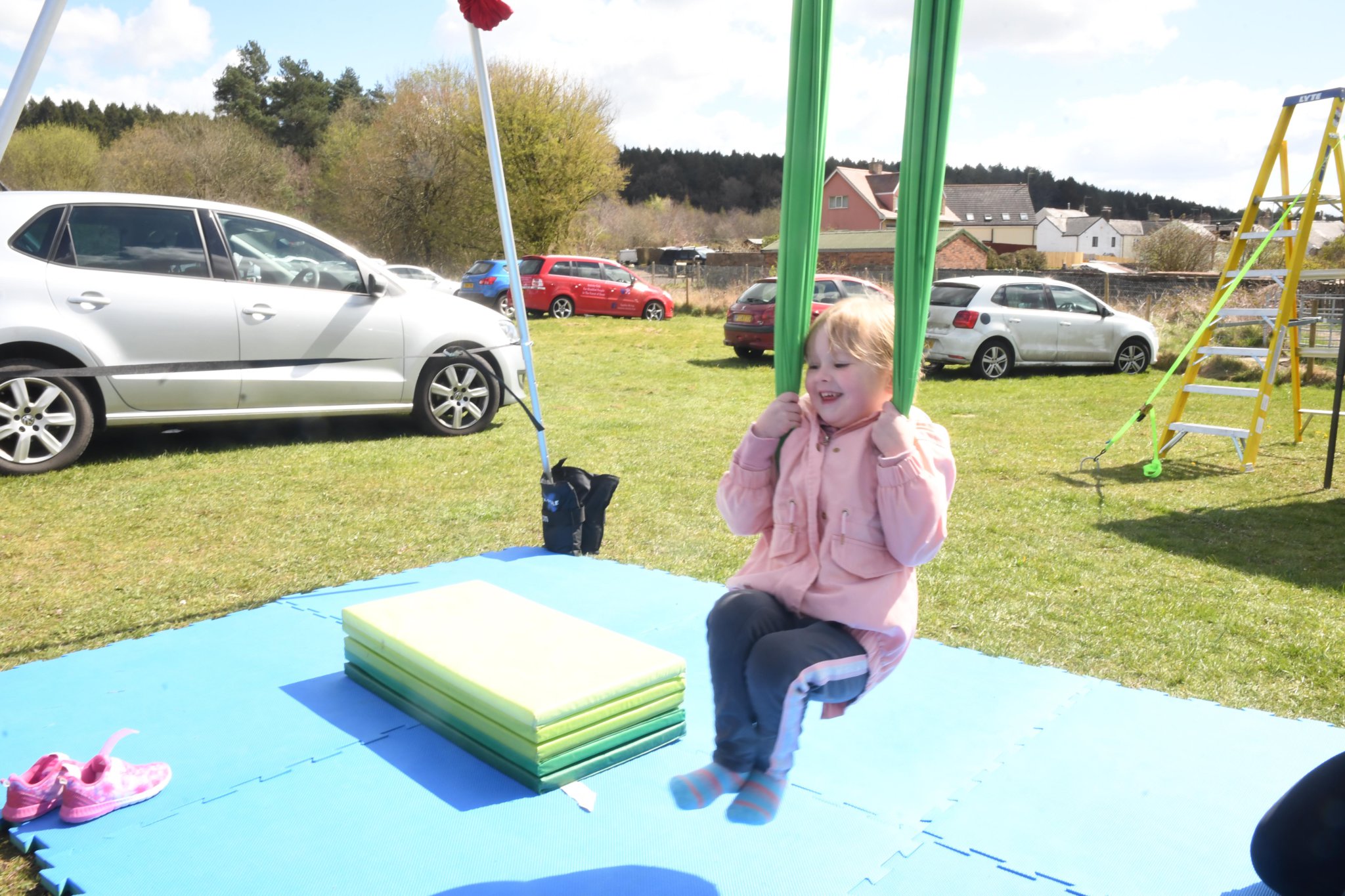 Eight-year-old Tyler Billett has a go at being a town crier with help from Ryan Morgan of Cinderford Town Council. Above right: Frederica Jones of Ruardean has a go on the swing set up by Cinderford Artspace .Right: Ilyana Watkins and Courtney Middleton from the Forest Youth Association were helping out with games on the field.