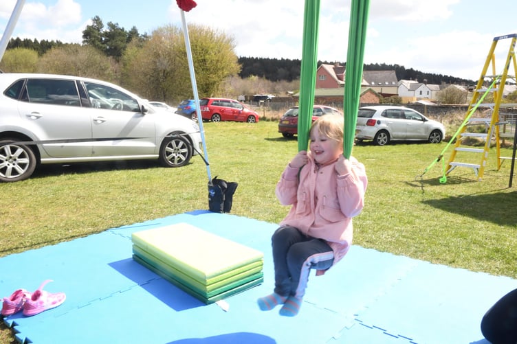 Eight-year-old Tyler Billett has a go at being a town crier with help from Ryan Morgan of Cinderford Town Council. Above right: Frederica Jones of Ruardean has a go on the swing set up by Cinderford Artspace .Right: Ilyana Watkins and Courtney Middleton from the Forest Youth Association were helping out with games on the field.