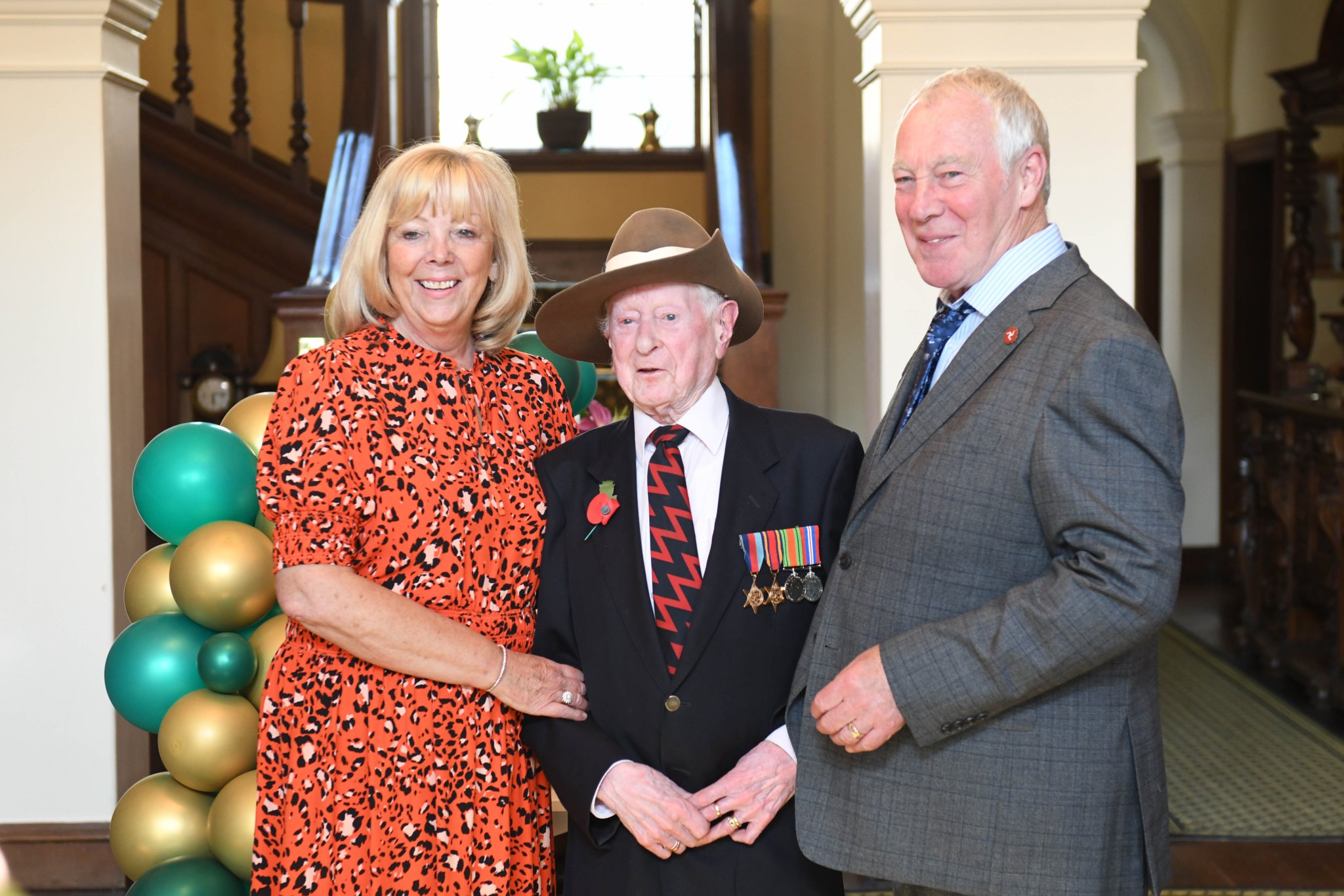A surprise celebration at Government House for the 100th birthday of Burma Star veteran James Fenton. Left to right: Sheila Healey, James Fenton and Tommy Healey
