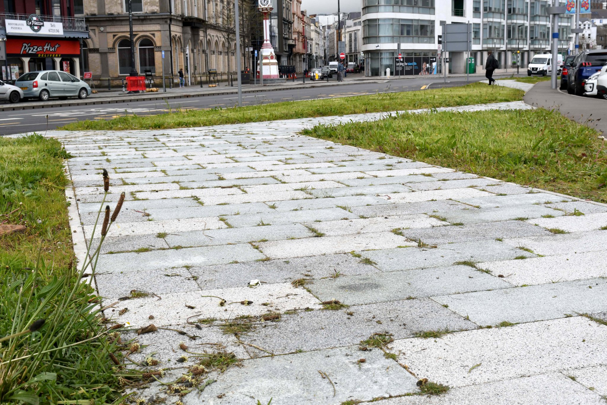 Weeds growing between new paving on Loch Promenade in Douglas -