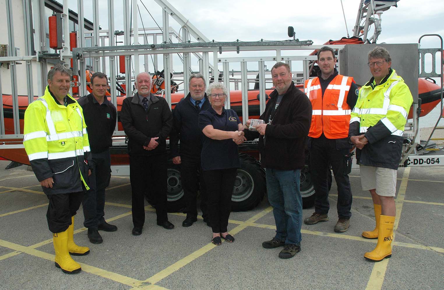 Right: John Slack (Photo: GoFundme). Above: Robert Slack is pictured here donating £2,300 to Aberdyfi Lifeboat Station. The money was raised by the friends and family of his son, John, who died at Tywyn beach last year. Photo: Doris O’Keefe