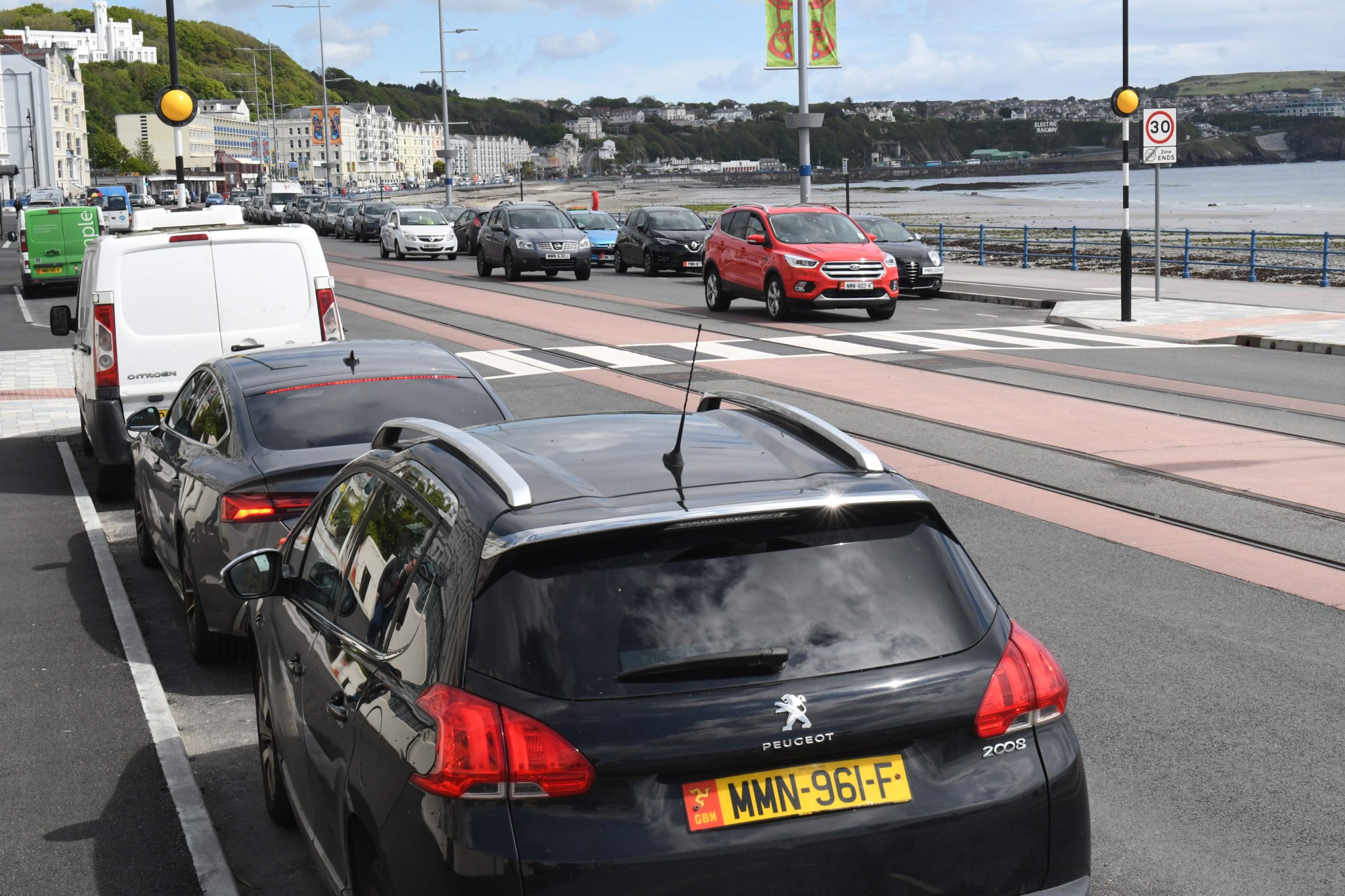 Parked cars adjoining a pedestrian crossing at the esplanade on Douglas Promenade -