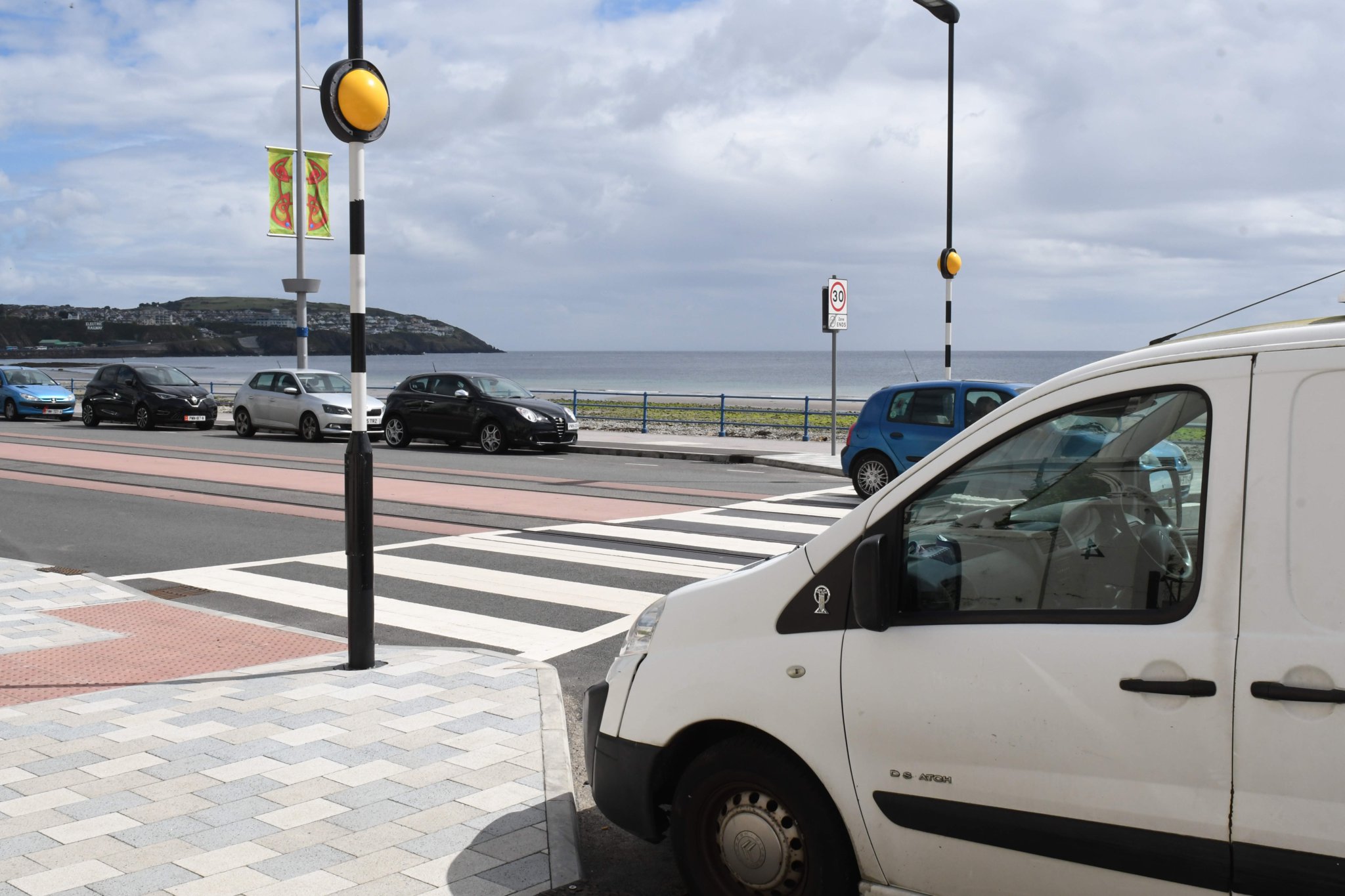 Parked cars adjoining a pedestrian crossing at the esplanade on Douglas Promenade -