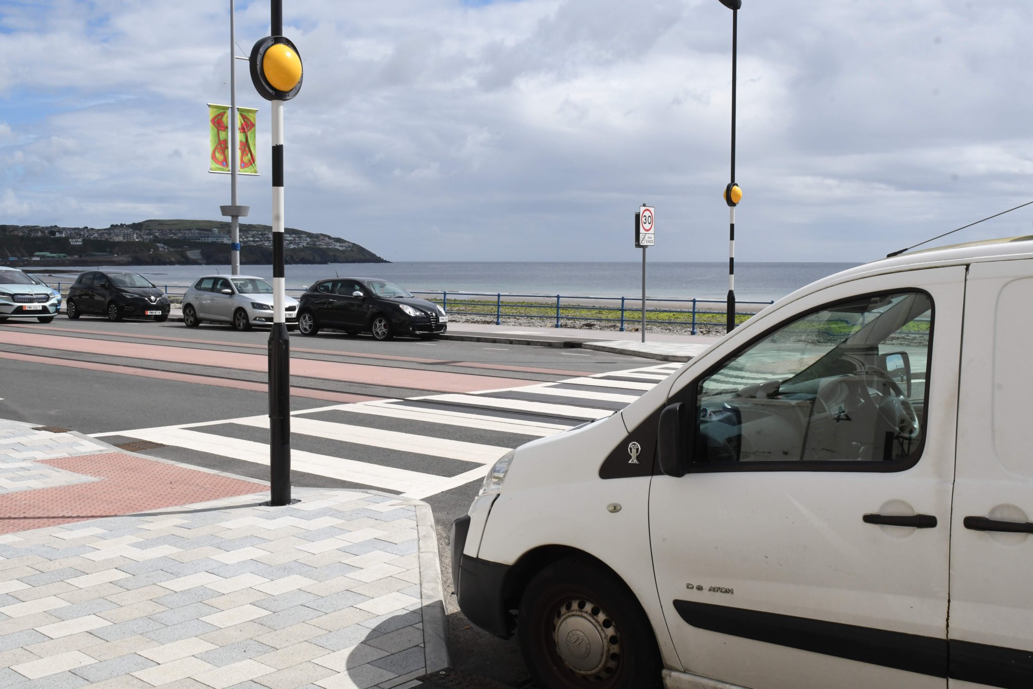 Parked cars adjoining a pedestrian crossing at the esplanade on Douglas Promenade -
