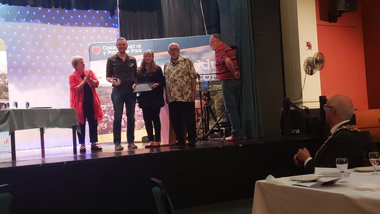 The Repair Cafe team receives their award and trophy from new councillor Trish Fretten