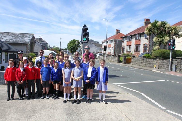 Police members and a child from Ashley Hill Primary School & Onchan Primary School at the pelican crossing in Onchan. Photo by Callum Staley (CJS Photography).
