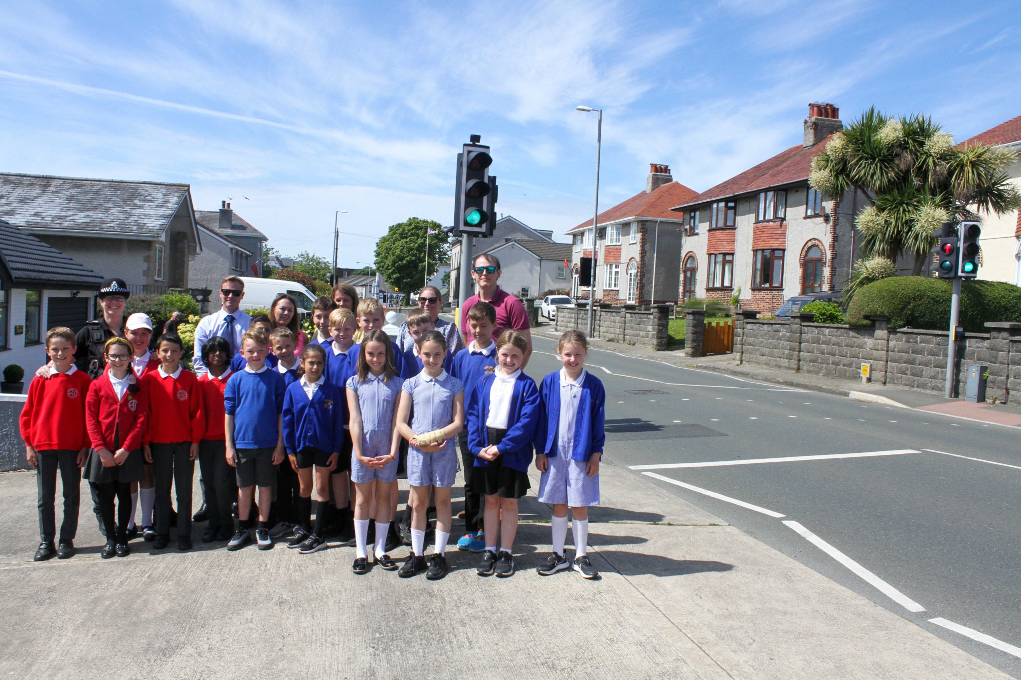 Police members and a child from Ashley Hill Primary School & Onchan Primary School at the pelican crossing in Onchan. Photo by Callum Staley (CJS Photography).
