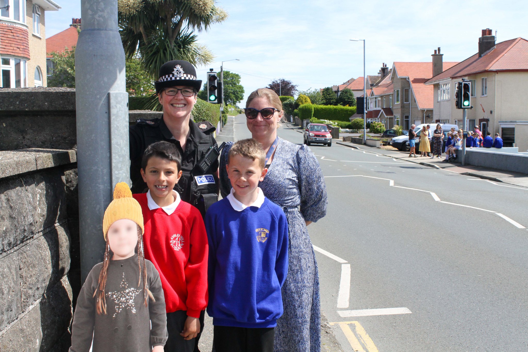 Police members and a child from Ashley Hill Primary School & Onchan Primary School at the pelican crossing in Onchan. Photo by Callum Staley (CJS Photography).