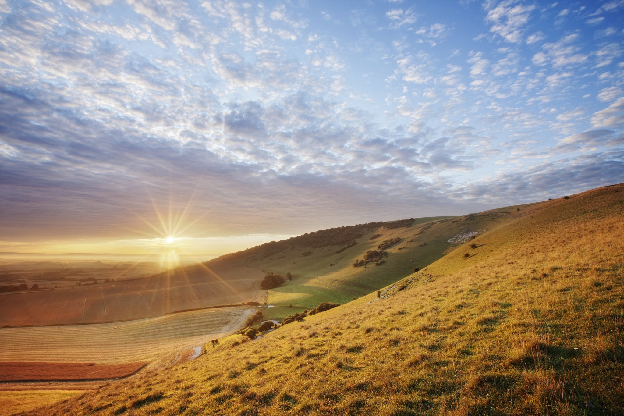 <p>Sunrise over chalk downland viewed from Wilmington Hill, Willmington, South Downs National Park, East Sussex, England, UK</p>