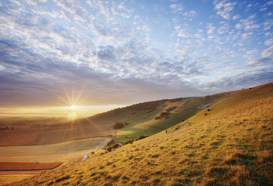 <p>Sunrise over chalk downland viewed from Wilmington Hill, Willmington, South Downs National Park, East Sussex, England, UK</p>