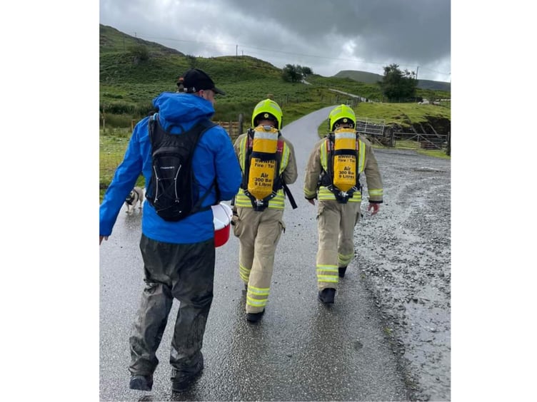 Stephen and Harry walk through rain showers with a supporter collecting donations