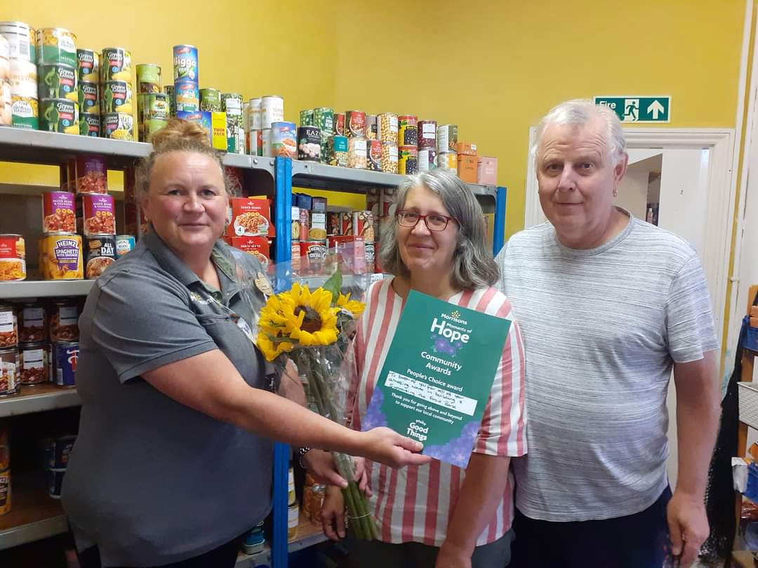 Mandy, left, presenting a Community Hero Award to Steve Gill and his wife.