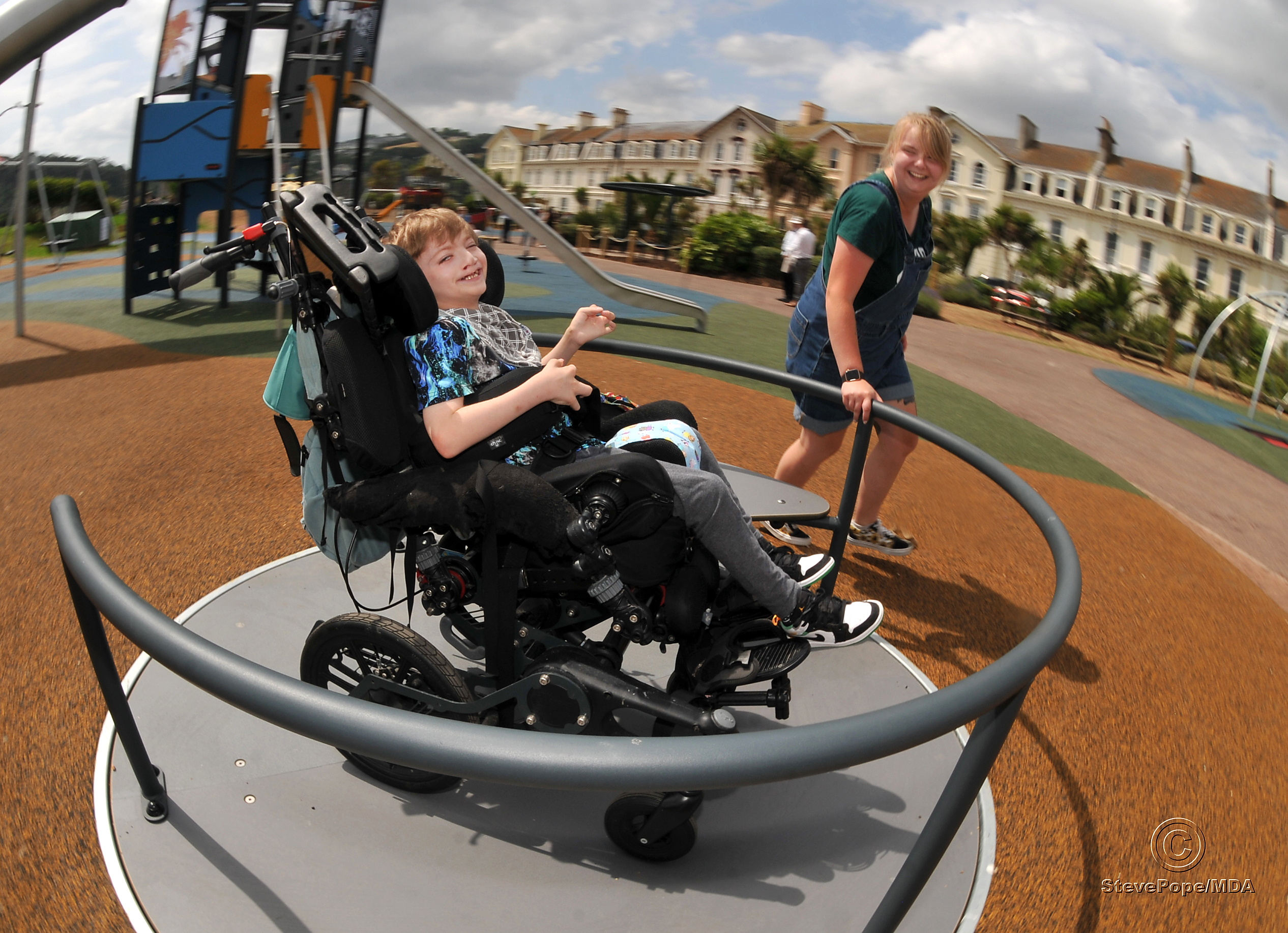 Children's playpark at The Den, Teignmouth, re-opens after refurbishment. You spin me right round....George Ellis (9) enjoys the new facilities, including this inclsuive roundabout, with a helping hand from his sister Jess Ellis
