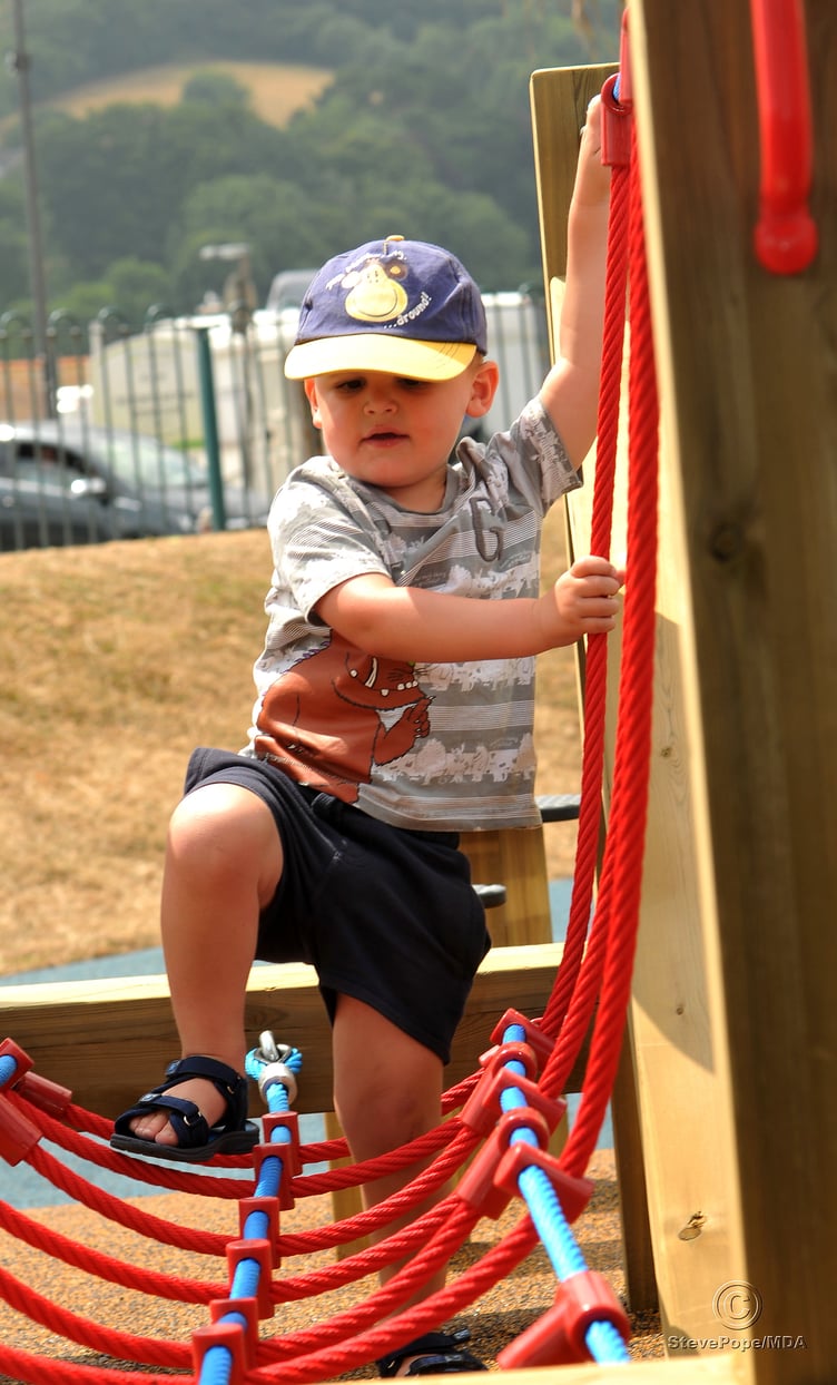 Children’s playpark at The Den, Teignmouth, re-opens after refurbishment.. Two-year old Jamie Waters from Newton Abbot gets to grip with the new equipment
