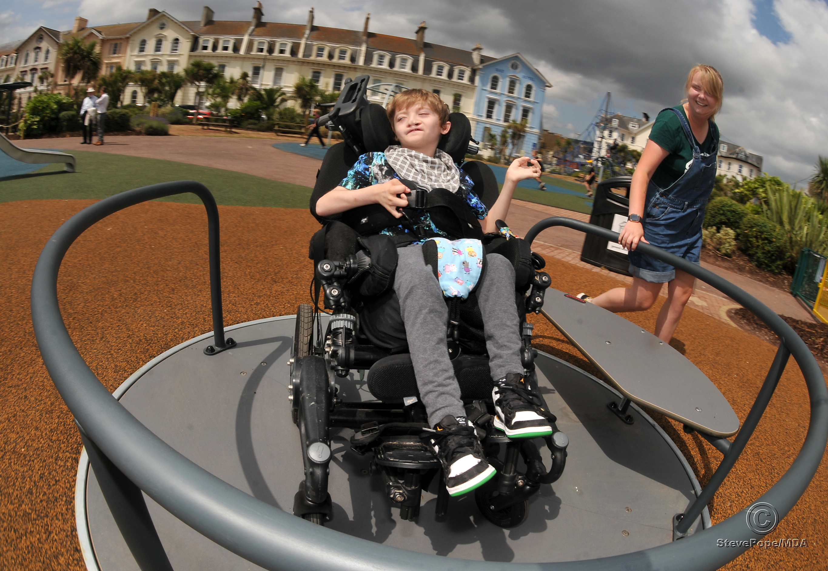 Children's playpark at The Den, Teignmouth, re-opens after refurbishment. You spin me right round....George Ellis (9) enjoys the new facilities, including this inclsuive roundabout, with a helping hand from his sister Jess Ellis
