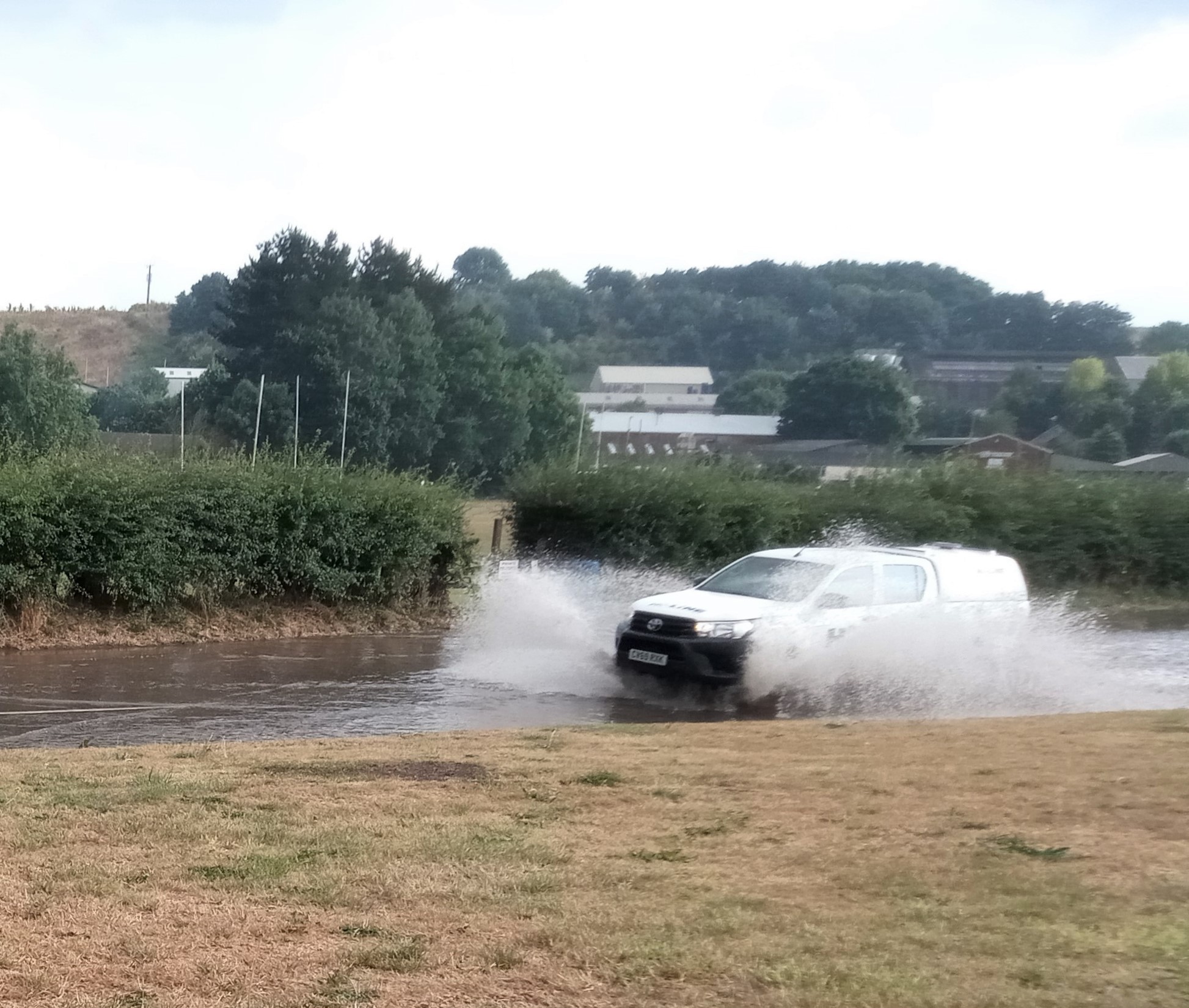 A vehicle travelling through the flooded Exhibition Road in Crediton.
