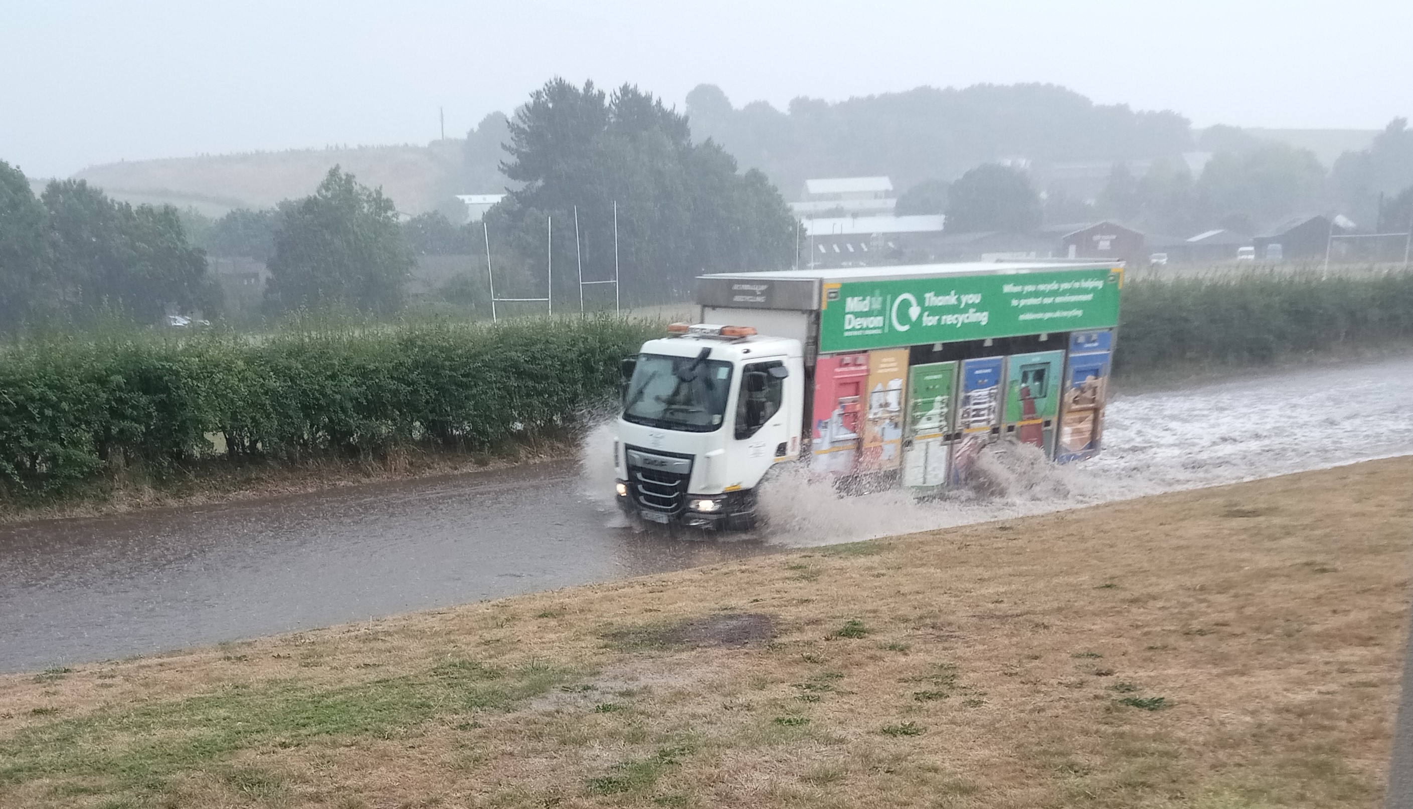 A recycling lorry making its way through the flooded road in Crediton.