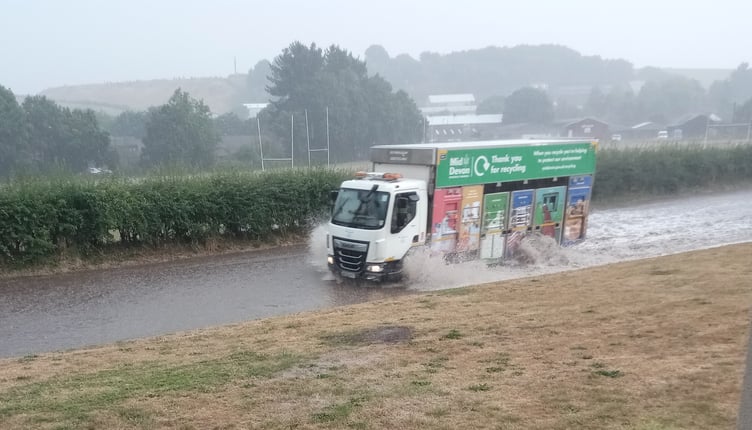 A recycling lorry making its way through the flooded road in Crediton.