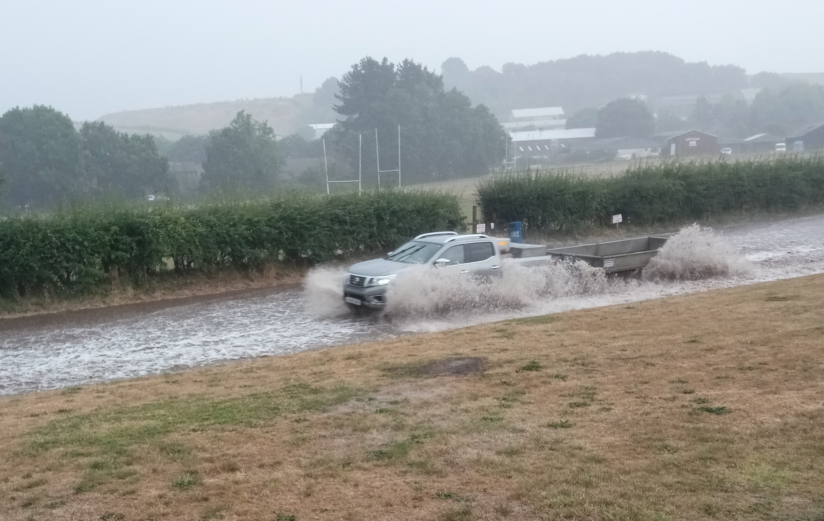 Vehicles travelling through the flooded Exhibition Road in Crediton.
