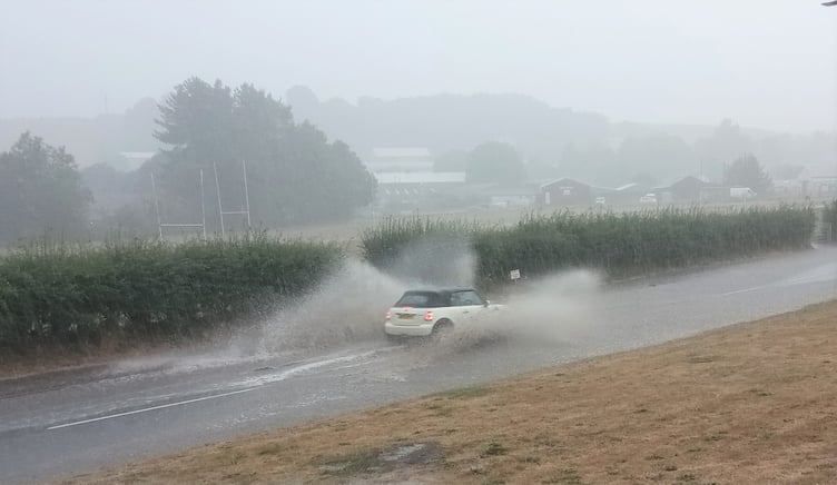 A vehicle travelling through the flooded Exhibition Road in Crediton.