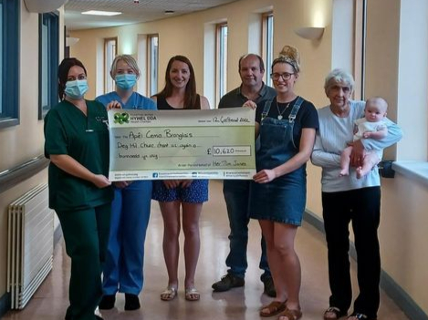 Pictured at the cheque presentation are health care support worker Rebecca Fletcher, staff nurse Sarah Garbutt, Caryl Jones, Rhydian Lloyd, Carys Jones, Glenys Jones and baby Mabli Jones