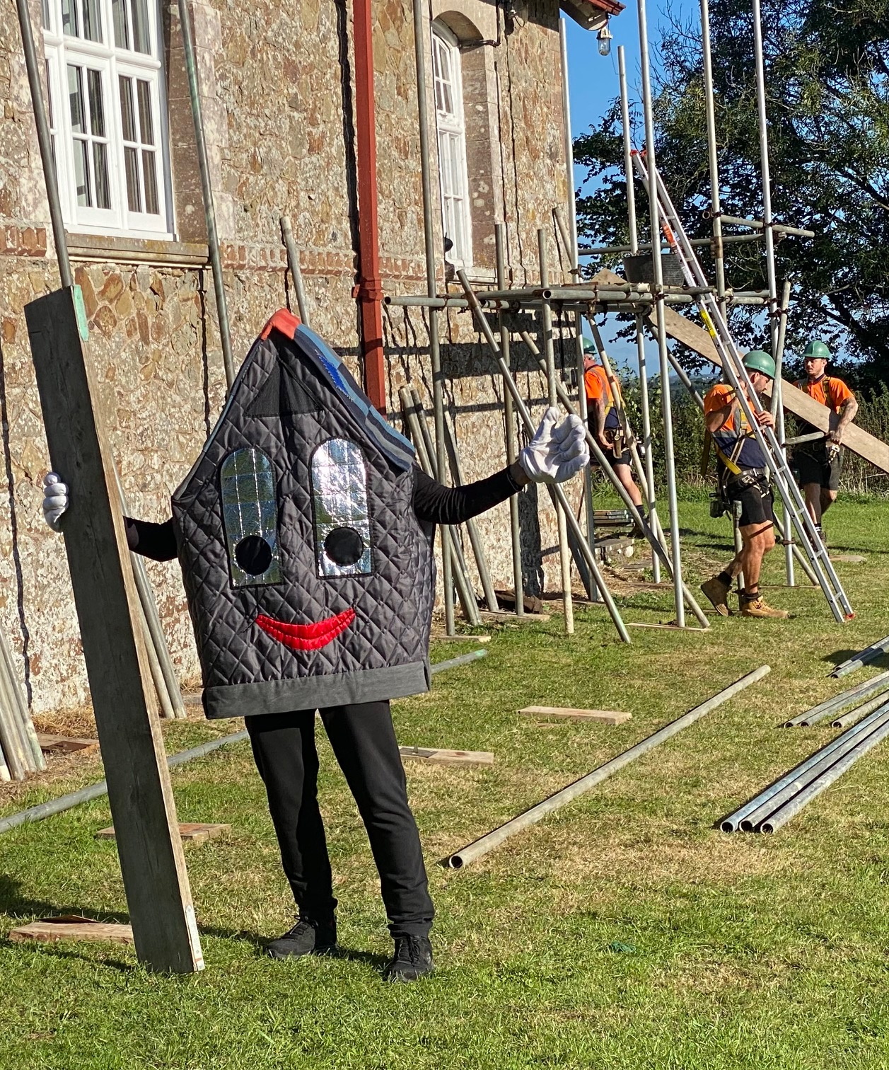ABOVE: The ‘Roof-Us’ mascot celebrates as the scaffolding goes up around Sampford Courtenay Village Hall.
