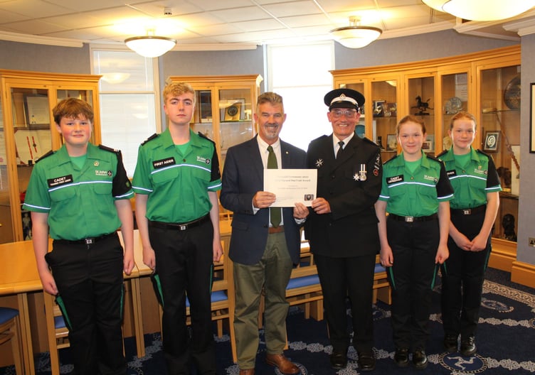 The President of Tynwald, the Hon Laurence Skelly, MLC, presenting the Best Turned Out unit Award to St John Ambulance youth support officer Eddie Littlewood alongside cadets Matthew Higgins, Matthew Gledhill and Shannon and Rebecca Kiely.