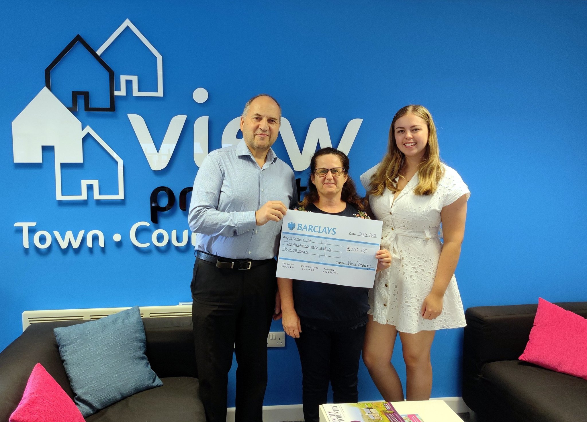 Mr and Mrs Pike receiving their cheque from Sophie at View Property