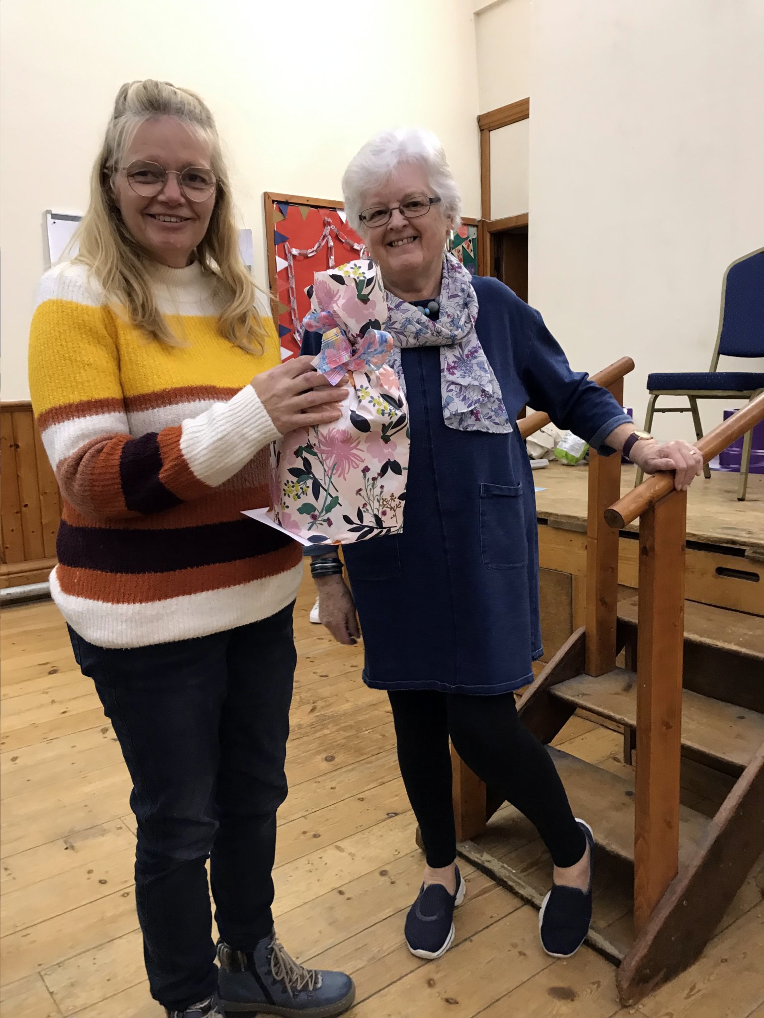 ABOVE: Gill Daniels, Dorothy Flaxman and Joan Trewin admire the WI flowering cherry tree; Below, Lynn Geldart receives a thank you gift from Carol Sparham