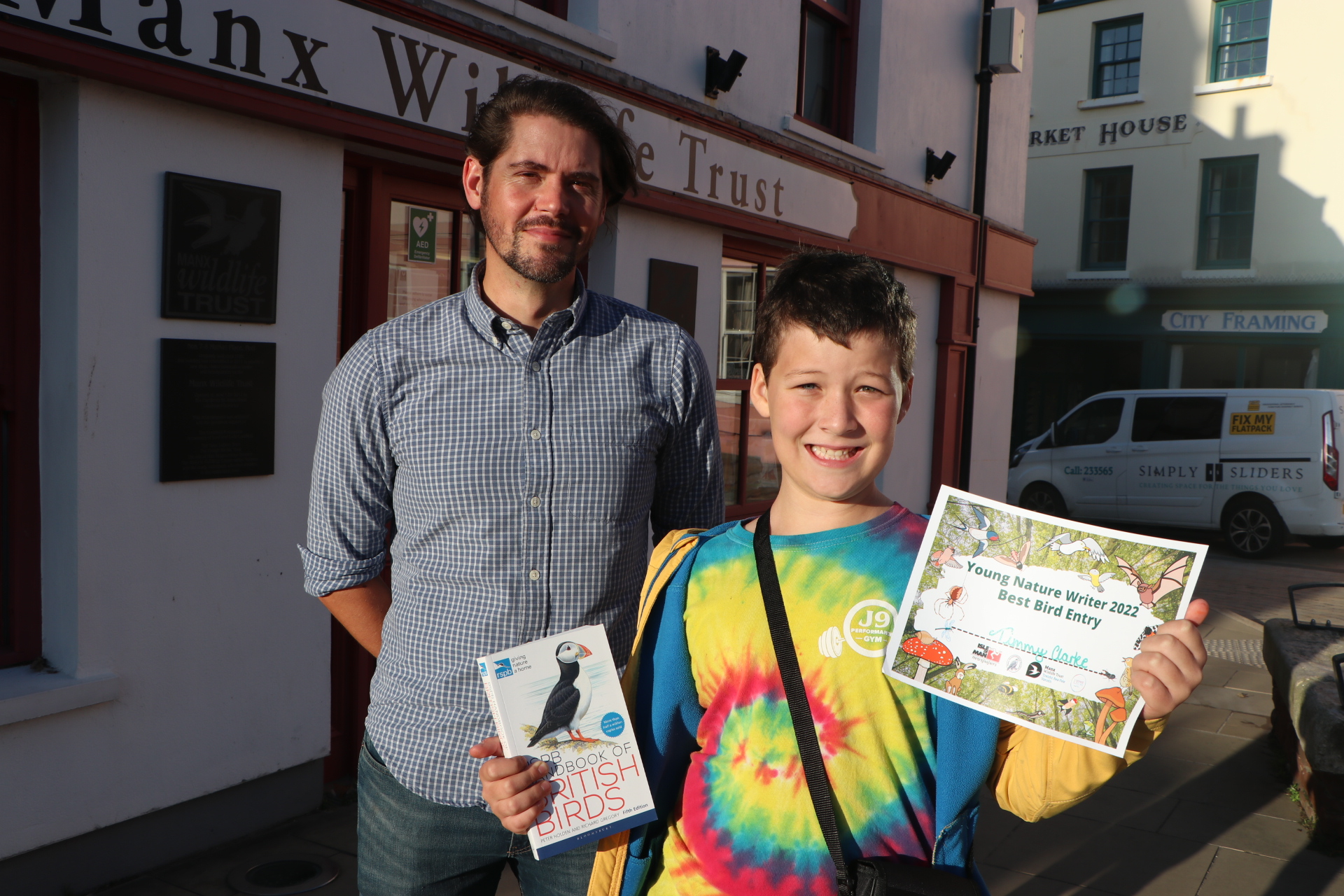 Rob Fisher of the Manx Ornithological Society presents binoculars and a bird guide to best bird entrant winner Timmy Clarke, 10