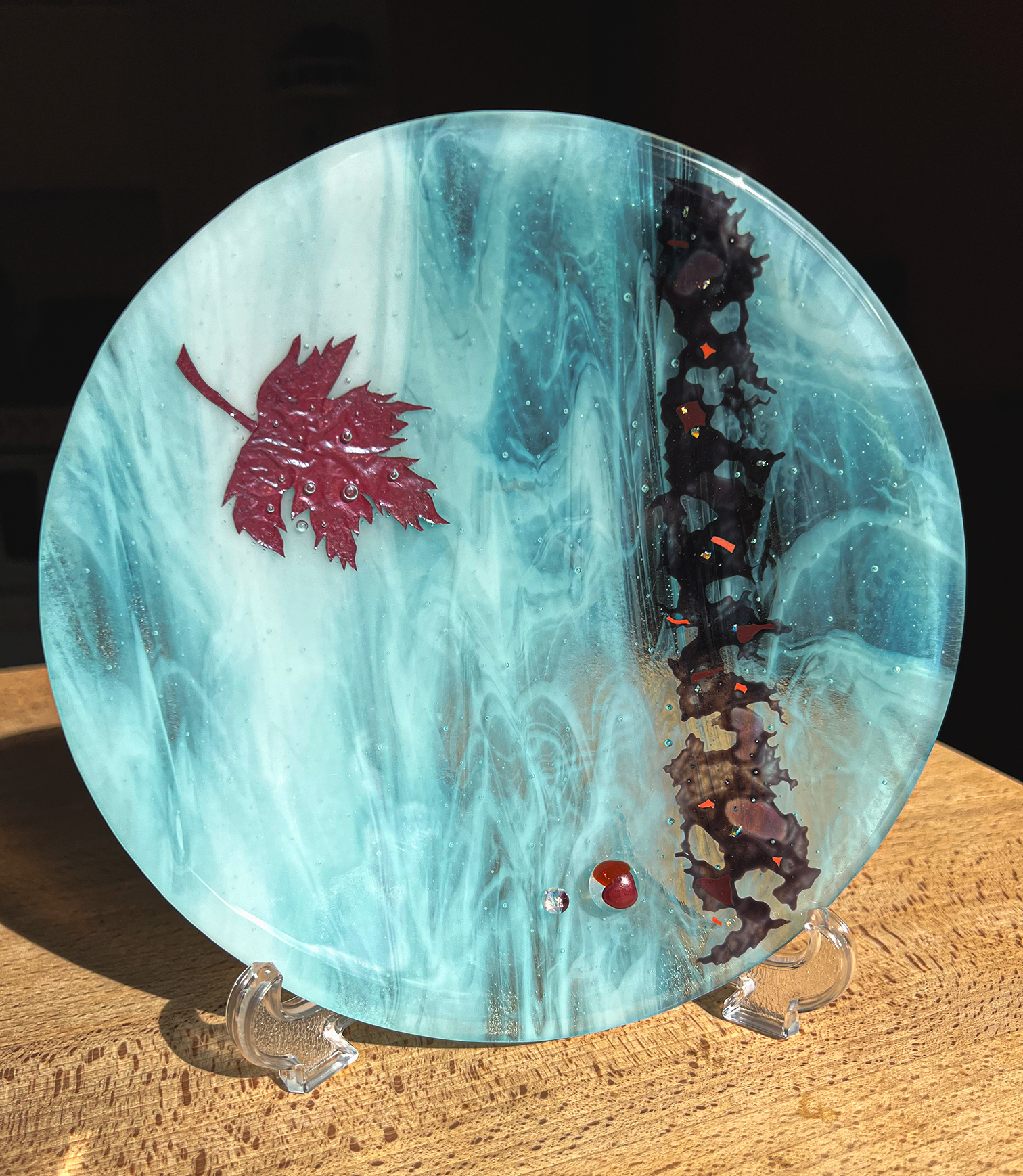 Metals such as silver, copper and brass can be encased within glass; these alloys oxidise in the heat and create effects that are often unpredictable.
