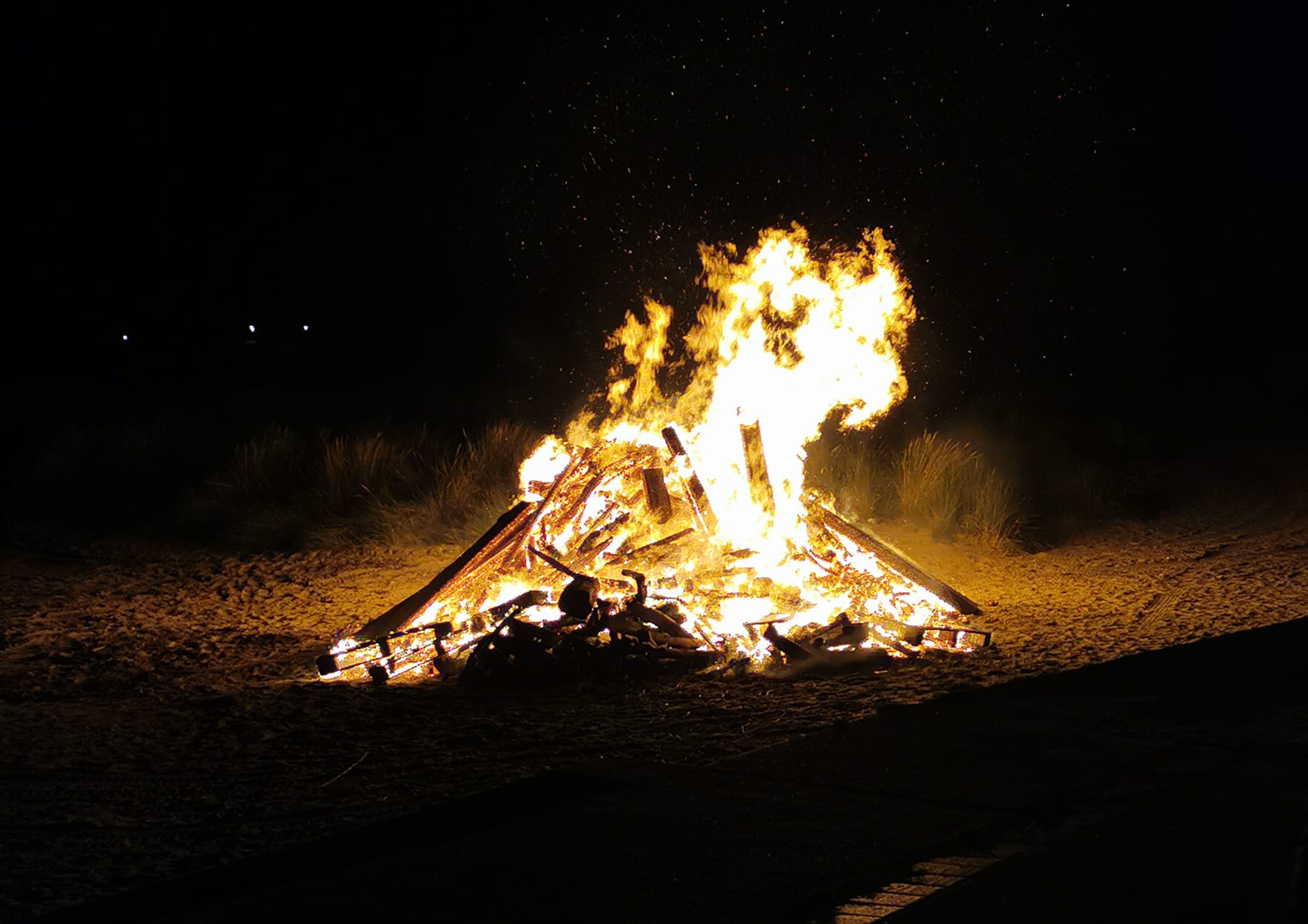 A bonfire blazes brightly in the Aberdyfi night, captured by Llinos Furneaux