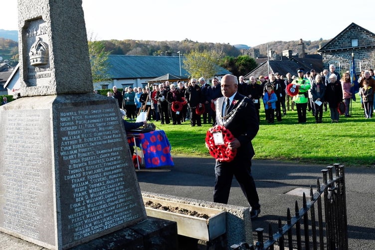 Mayor of Dolgellau, Cllr John Raghoobar, places a wreath on behalf of Dolgellau Council at the war memorial on Sunday