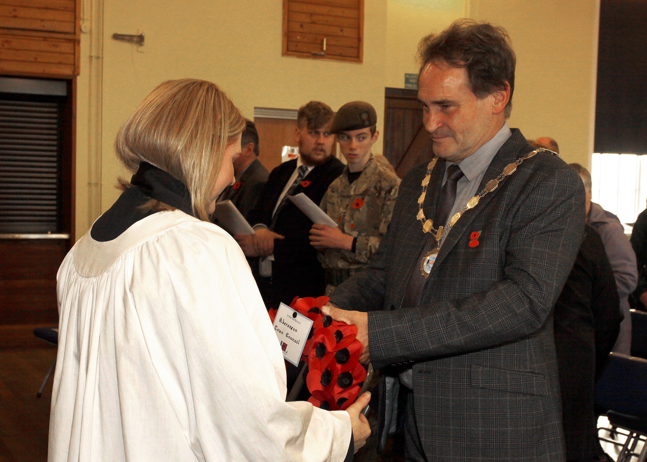 Cllr Darryl Evans, mayor of Aberaeron, presents the wreath on behalf of the people to the Curate Rev Heulwen Evans