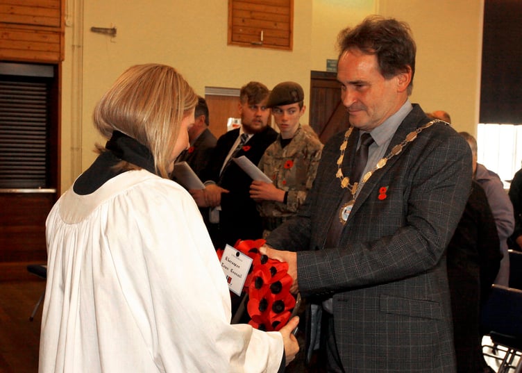 Cllr Darryl Evans, mayor of Aberaeron, presents the wreath on behalf of the people to the Curate Rev Heulwen Evans