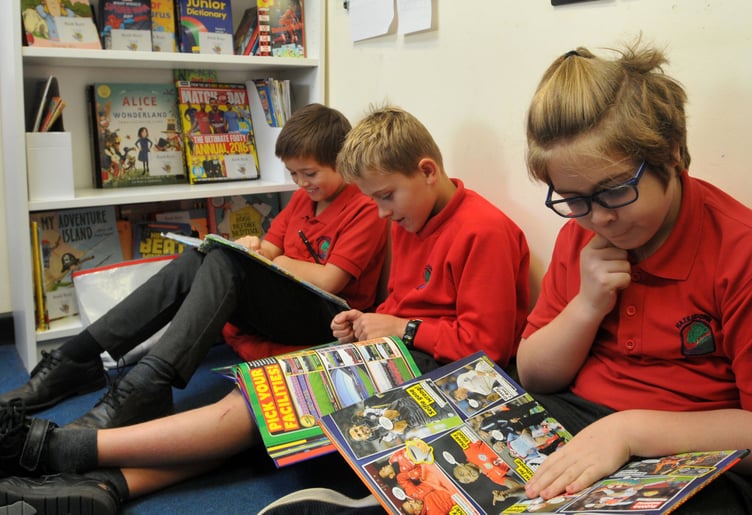 ABOVE: Deputy head Lee Goodenough with delighted members of Teignmouth Rotary Club.
RIGHT: Engrossed in a good book – KS1 pupil Hunter.