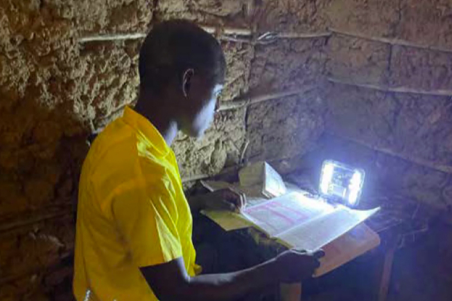 <p>A pupil from Menzamwenye School in rural Kenya studying at home with a Mwezi light</p>