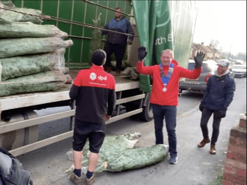 Farnham Round Table volunteers unload the first batch of charity Christmas trees ready for Saturday’s home deliveries across the area – the Round Table project raises thousands of pounds for local good causes every year