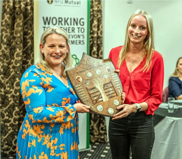 Last years Bradworthy Secretary, Karen Cawsey, collecting the Bowden Shield for Outstanding Individual Contribution in the Year from outgoing Devon County Chairman Rosie Bennett