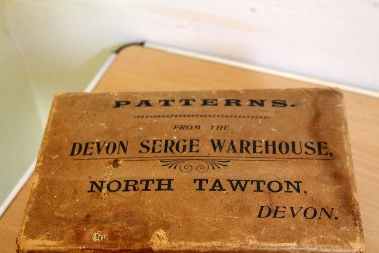 Inscription on a box of patterns from the Devon Serge Warehouse in North Tawton. SR 6468