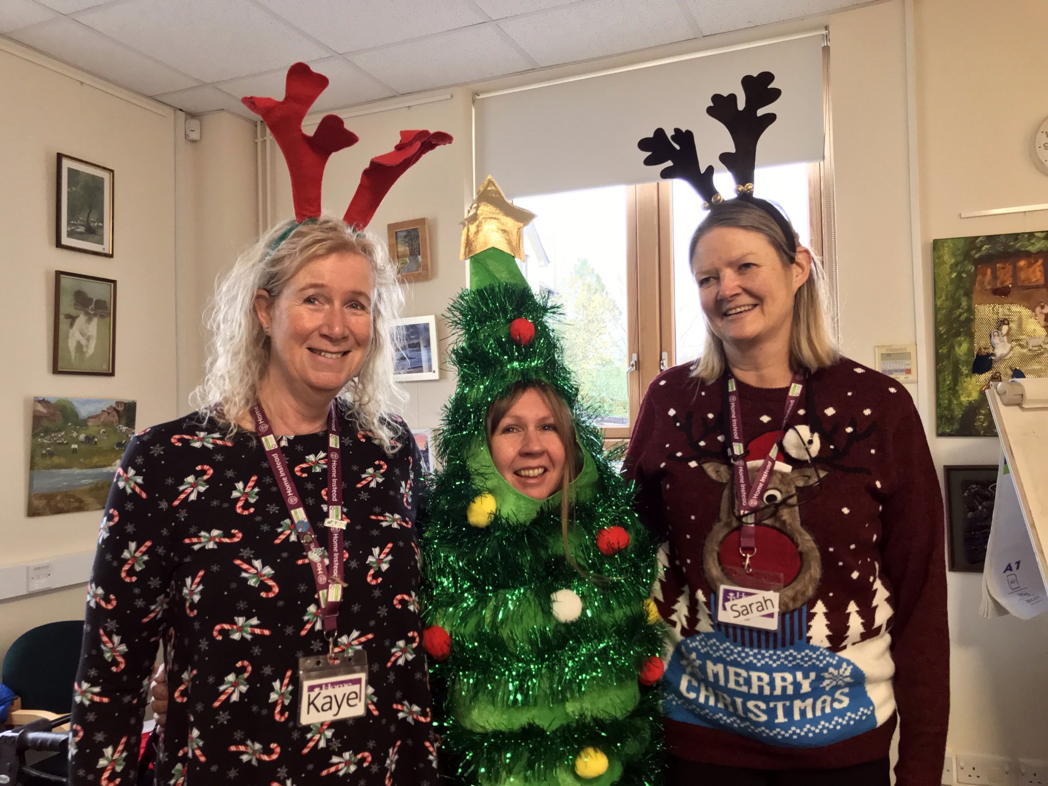 From left Kaye Rogers, Sue Houlberg and Sara Woolley of Home Instead and, below, Sue shows off her Christmas tree costume.