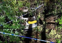 Two people trapped as car slides down sharp bank and crashes in woods