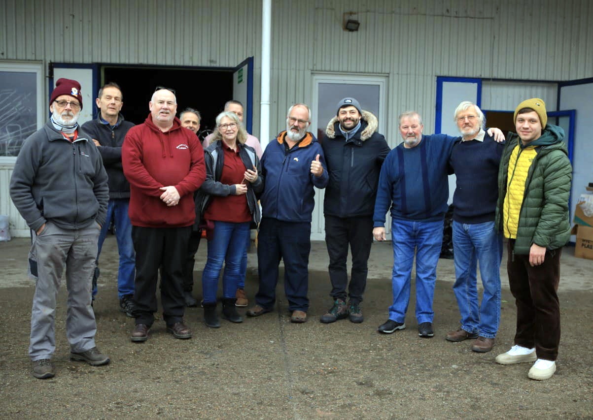 Darren Tait (left in red) with other volunteers, and refugees in Ukraine on the most recent trip.