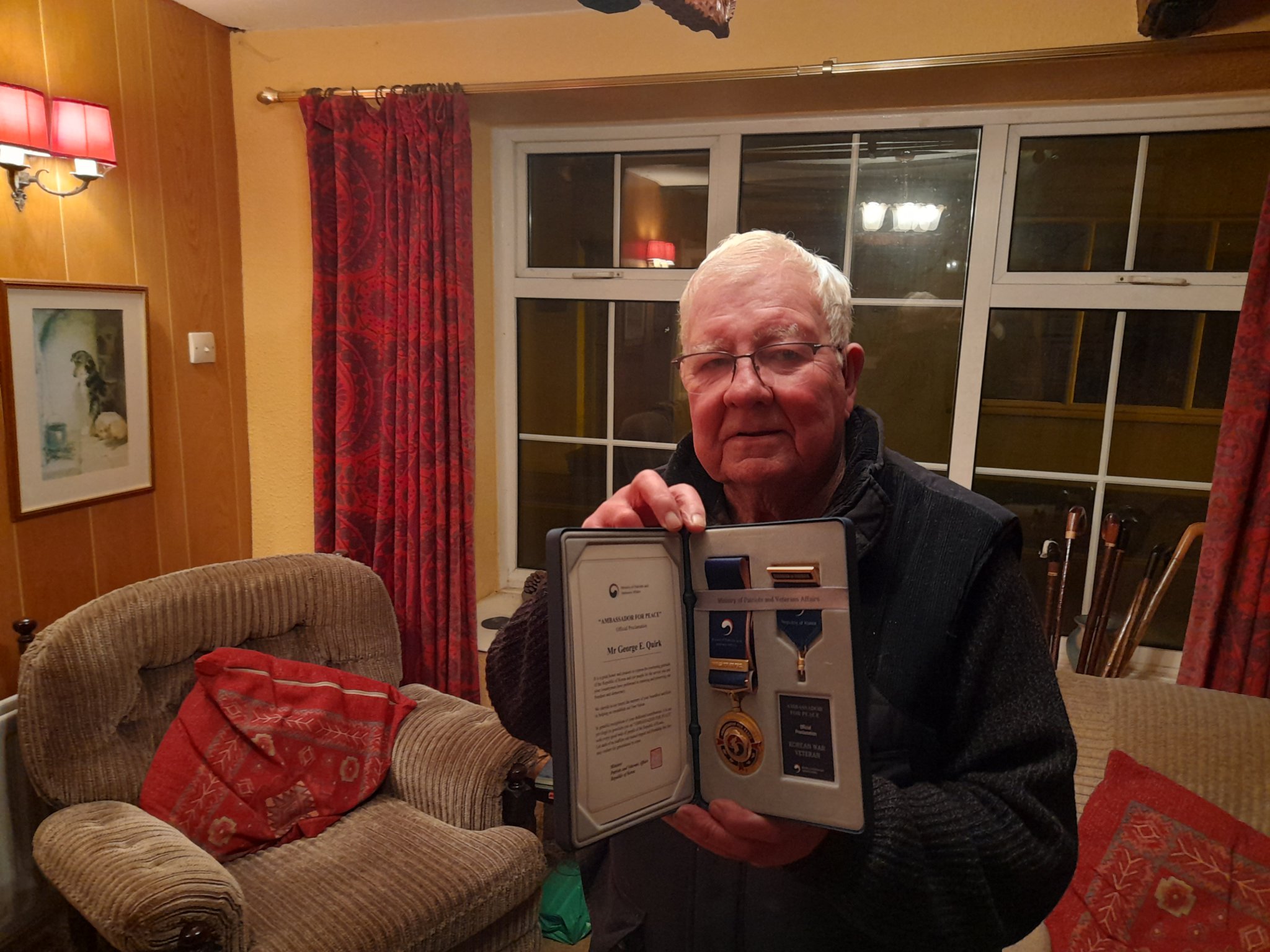 Eric Quirk in his Castletown home holding his medals