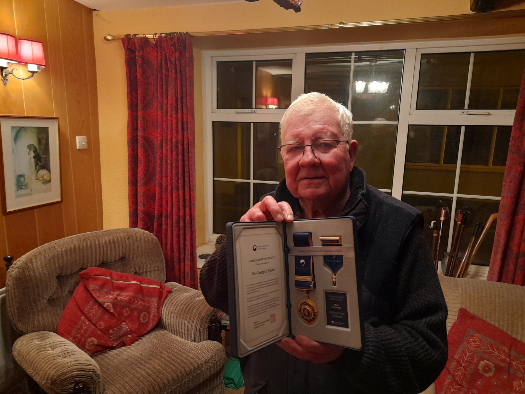 Eric Quirk in his Castletown home holding his Medals