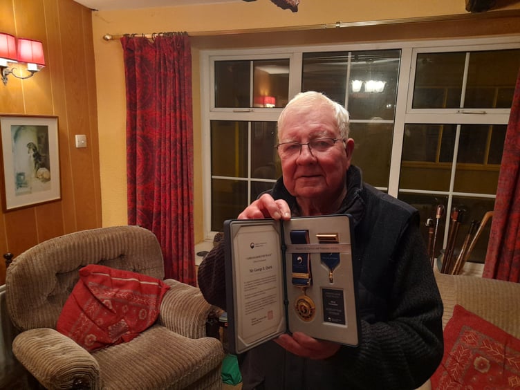 Eric Quirk in his Castletown home holding his Medals