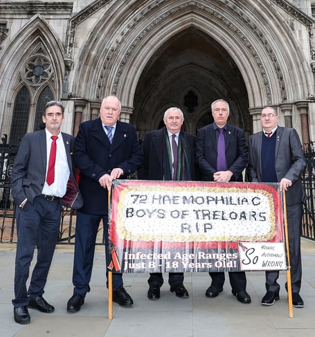 Four surviving Treloar's victims of the infected blood scandal join Des Collins, senior partner at Collins Solicitors, to make their case outside the High Court in London, January 24th 2022.